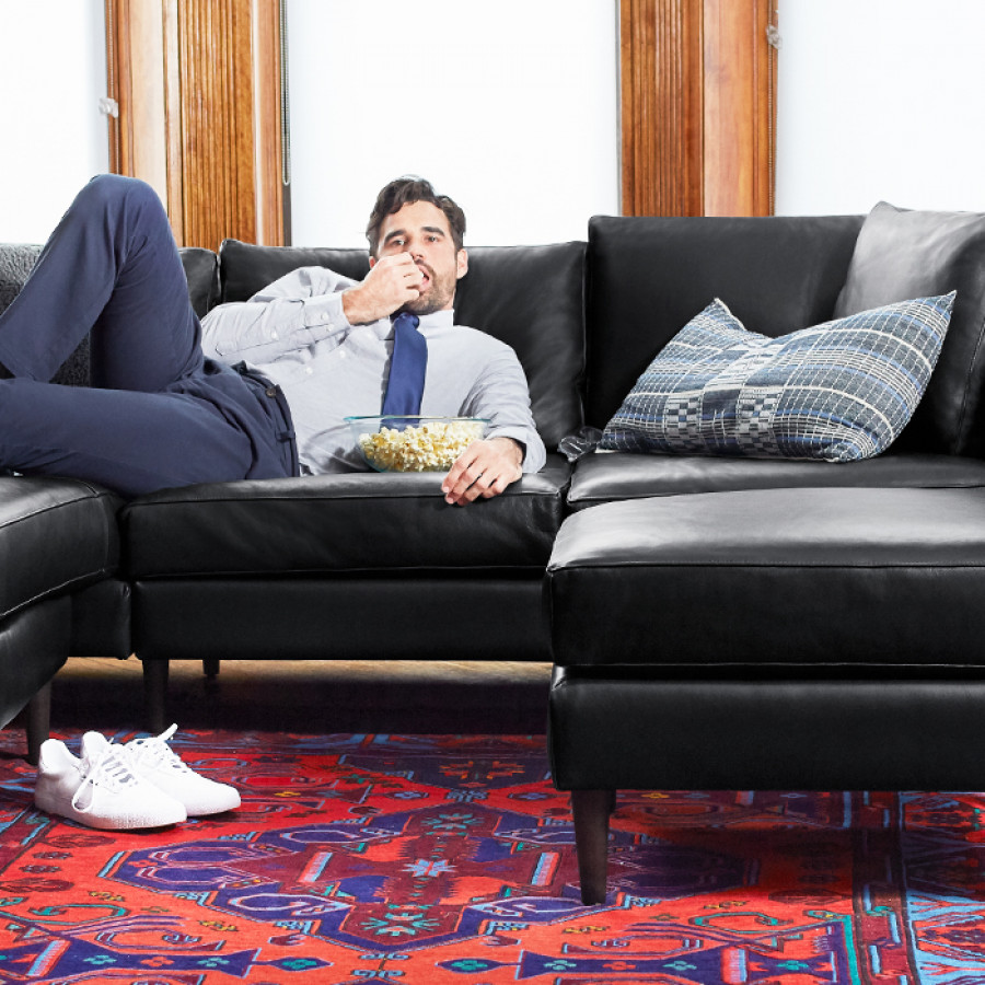 Man lounging on dark smoke leather Allform sofa