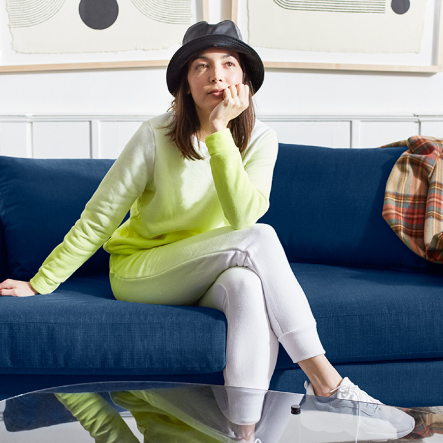 Woman Sitting on Dark Blue Loveseat
